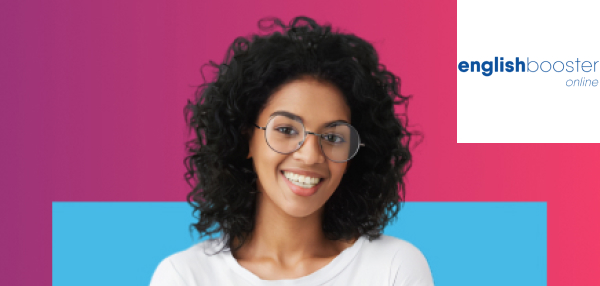  Mulher negra vestindo uma camiseta branca está de braços cruzados e sorri.